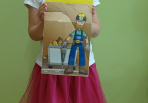 Dziewczynka pokazuje ilustrację górnika