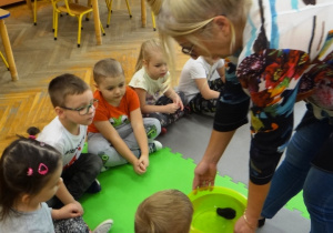 Dzieci obserwują, czy węgiel rozpuszcza się w wodzie