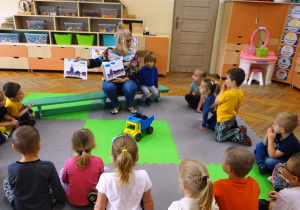 Nauczycielka prezentuje prace plastyczne wykonane przez dzieci