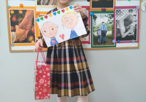 Dziewczynka pokazuje portret Babci i Dziadka