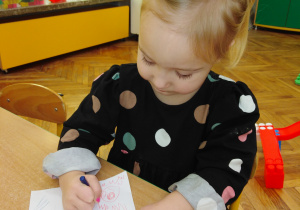 Dziewczynka rysuje lalkę