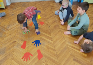 Dzieci bawią sie ze stopami i dłońmi