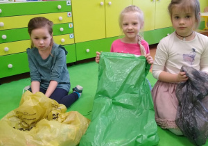 Trzy dziewczynki z workami na odpowiednie odpady