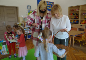 Pani wicedyrektor i nauczycielka wręczają nagrody przedszkolakom