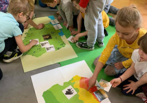 Dzieci dopasowują miejsca do mapy Polski