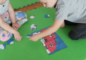 Chłopiec układa mapę Polski z puzzli