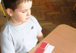 Chłopiec układa flagę Polski