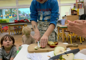 Dziecko uczy się kroić owoce