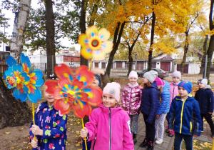 Dzieci idą z wiatrakami do ogrodu przedszkolnego