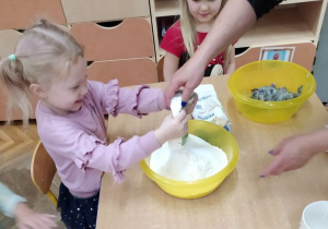 Dziewczynka wsypuje mąkę