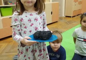 Dziewczynka prezentuje węgiel