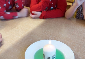 Dzieci obserwują palacą się świeczkę