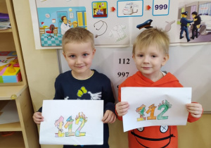Chłopcy prezentują swoje rysunki