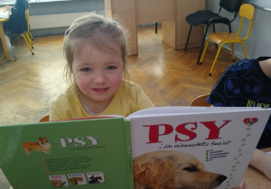 Dziewczynka ogląda książkę o psach