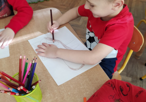 Chłopiec koloruje rysunek