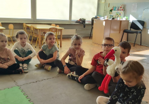 Dzieci podają sobie maskotkę bociana