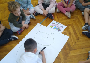 Chłopiec rysuje świnkę
