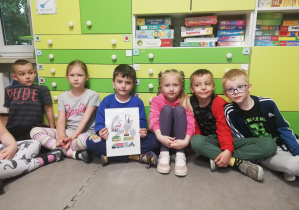 Dzieci prezentują planszę edukacyjną