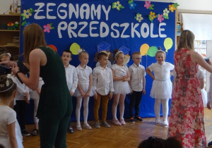 Nauczycielki zakładaja birety dzieciom