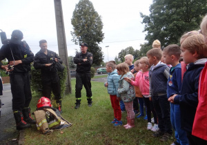 Dzieci obserwują wyposażenie wozu strażackiego