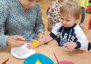 Nauczycielka maluje rączki dzieciom